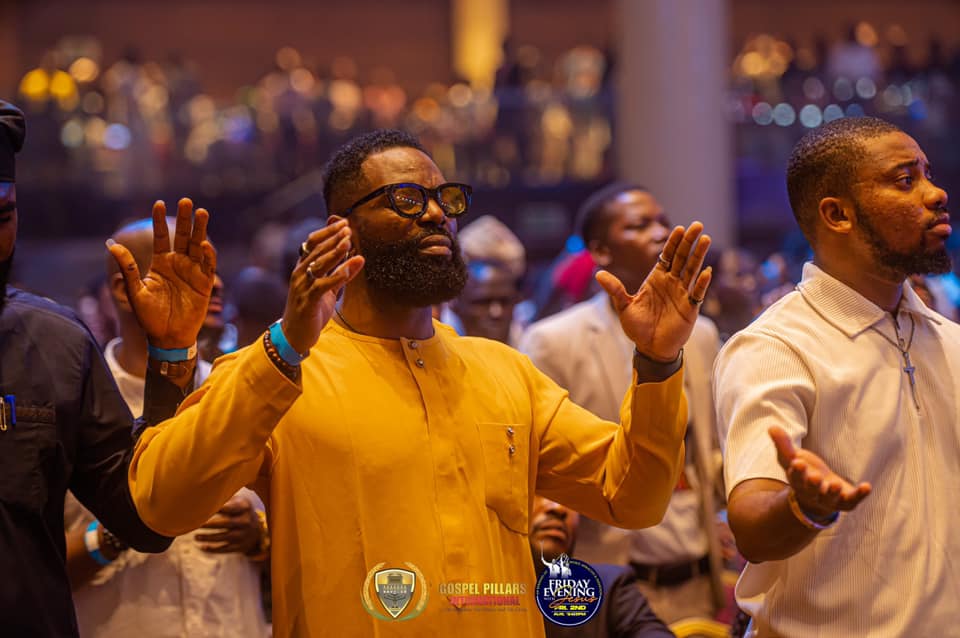 A worshipper with hands raised in the crowd at Eko Convention Centre, Lagos