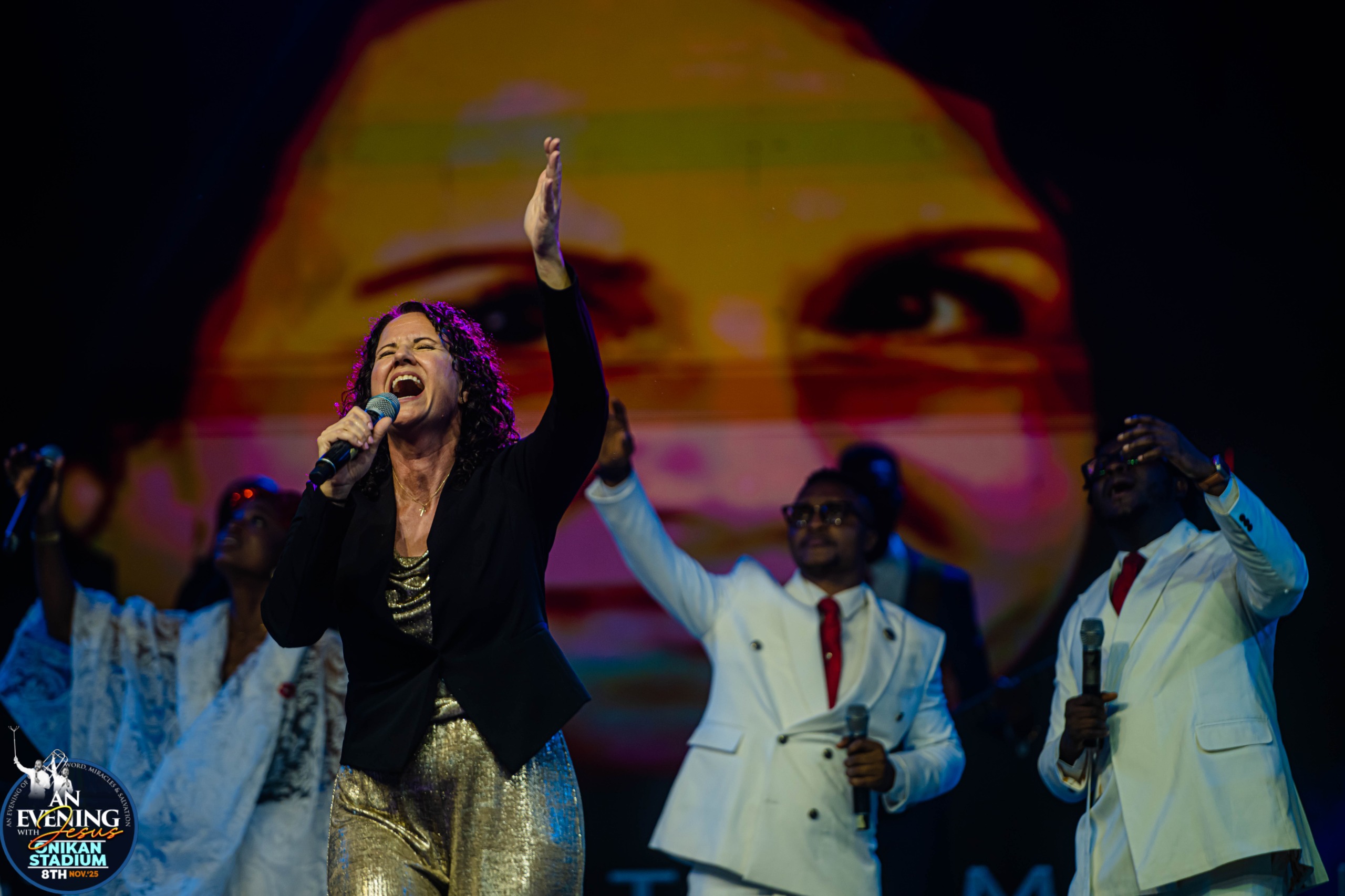 A guest minister singing with the choir on stage at Onikan Stadium