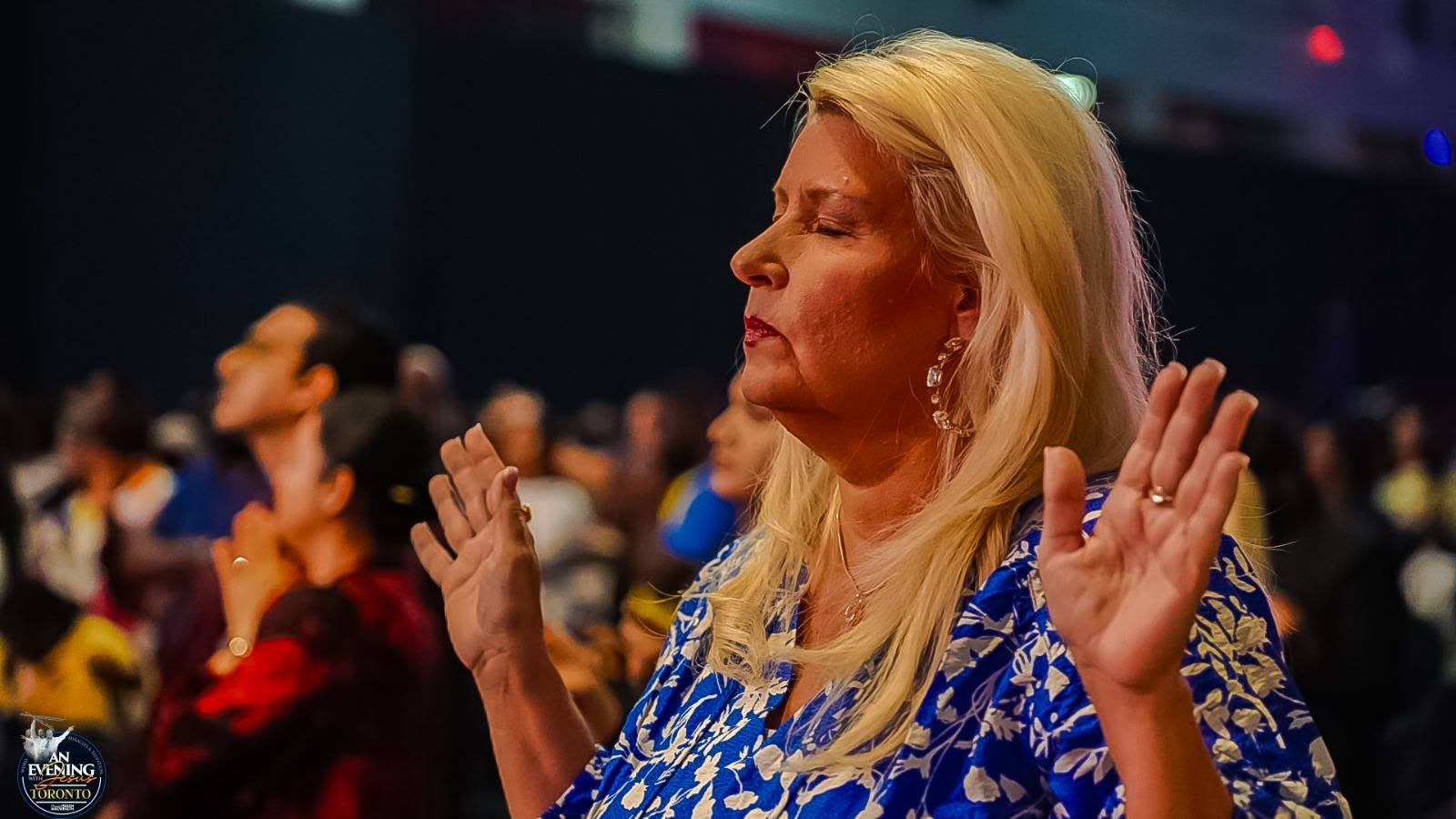 A worshipper lifting her hands in prayer at An Evening With Jesus, Toronto