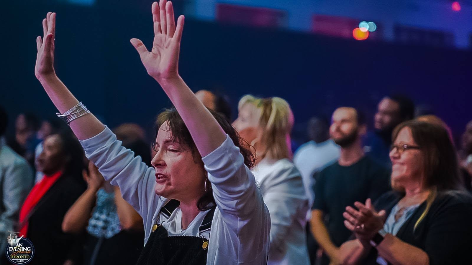 Worshippers with hands raised at An Evening With Jesus, Toronto